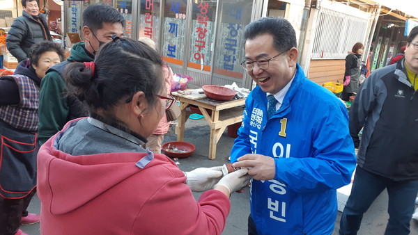 이용빈 후보가 송정5일시장 상인 손녀가 거낸 음료를 받고 환하게 웃고 있다. ©AI타임스