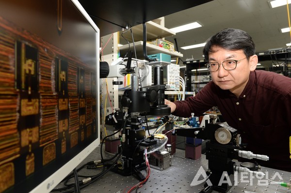 ETRI 한영탁 책임연구원이 400G 광학송수신엔진에 사용된 반도체 광원 칩을 살펴보고 있다.