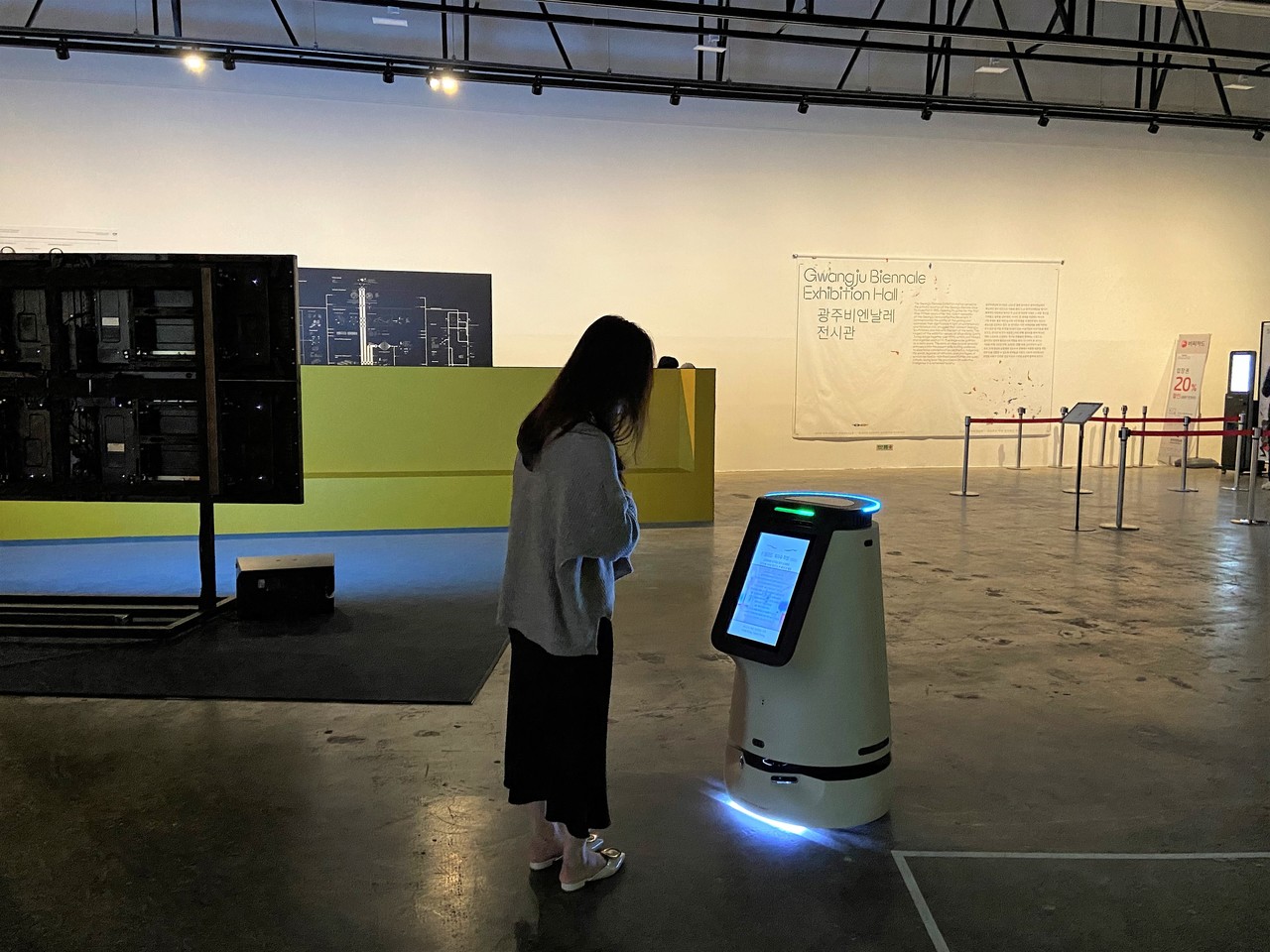 평일 낮, 한산한 시간에 비엔날레 전시관을 찾은 시민들은 모두 한 번씩 로봇에게 시선을 두었다. 한 시민이 작품해설을 읽는 모습. (사진=박혜섭 기자).