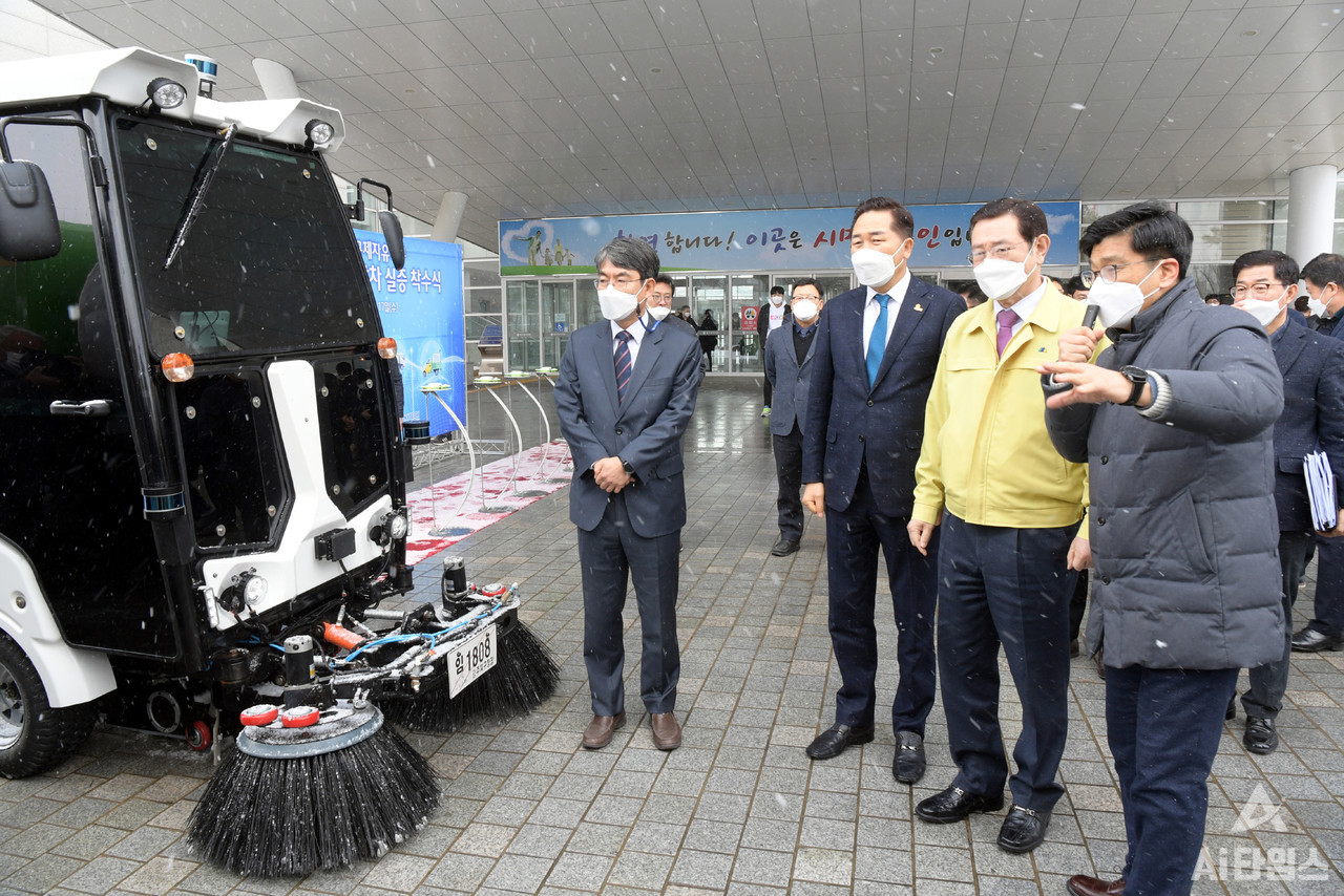 이용섭 광주광역시장이 지난 2월 17일 오전 시청 시민홀에서 열린 광주 무인저속특장차 규제자유특구 실증 개시에 따른 착수식에 참석한 후 청사 광장에 전시된 특장차와 노면청소차에 대한 설명을 듣고 시연을 하고 있다. (사진=광주시 제공).