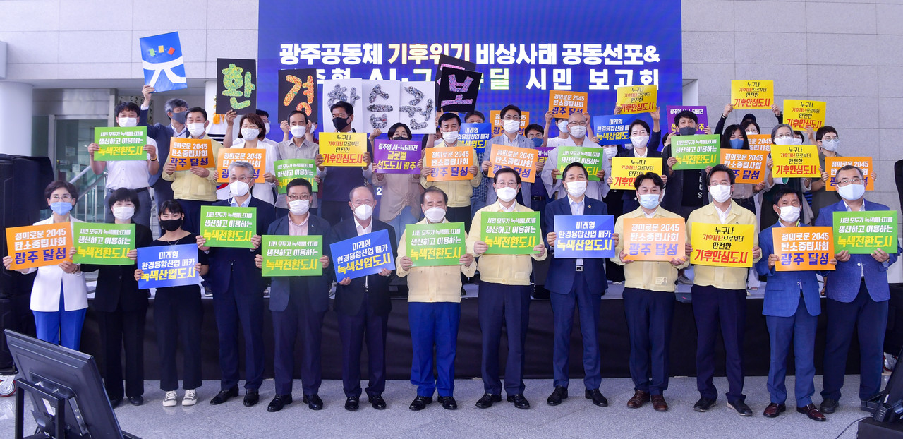 이용섭 광주광역시장이 지난해 8월 19일 오후 시청 1층 시민홀에서 열린 광주공동체 기후위기 비상사태 공동선포 및 광주형 AI-그린뉴딜 시민 보고회에 참석해 김용집 광주시의회 의장, 장휘국 광주시교육감, 5개 자치구 관계자들과 함께 기후위기 극복과 그린뉴딜 실천을 다짐하는 퍼포먼스를 하고 있다. (사진=광주시 제공).