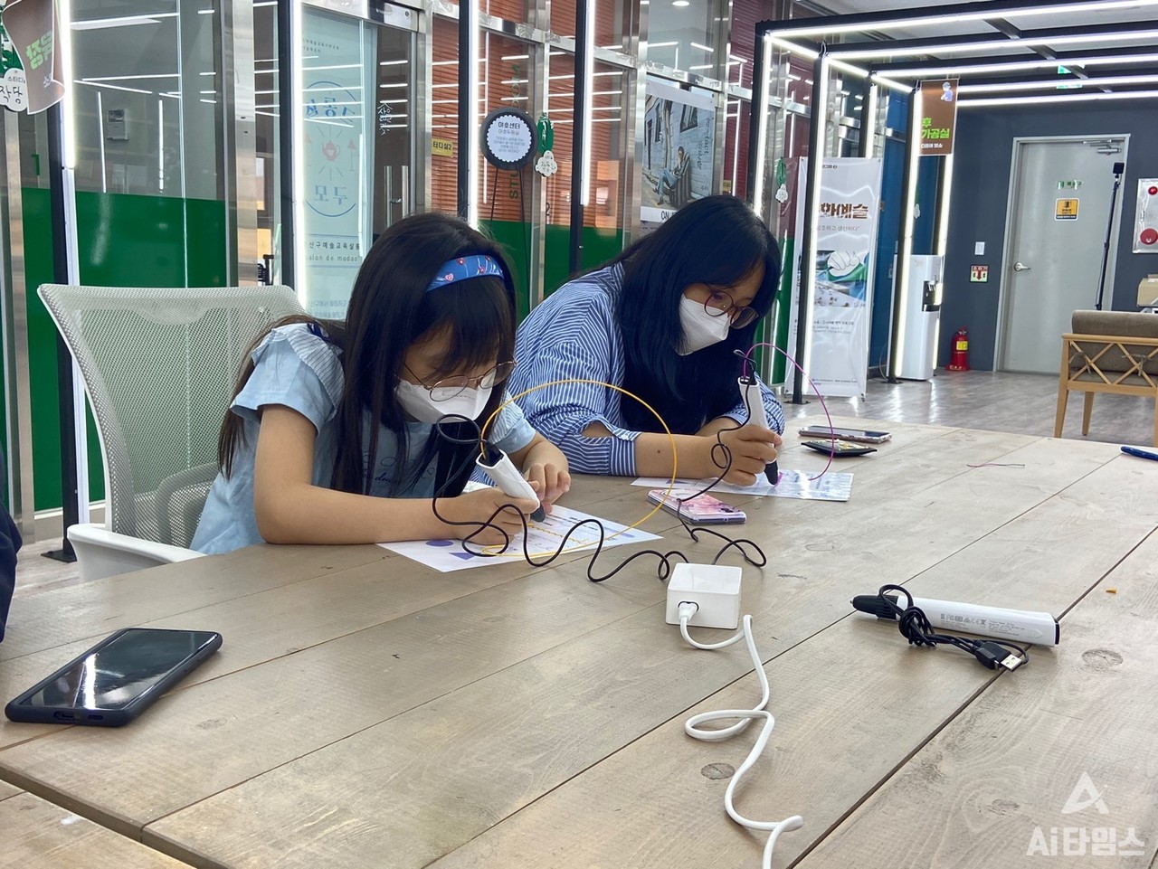 한 모녀가 각자 마음에 드는 필라멘트를 3D펜에 꽂아 연습용 도면 테두리를 그리고 있다. (사진=박혜섭 기자). 