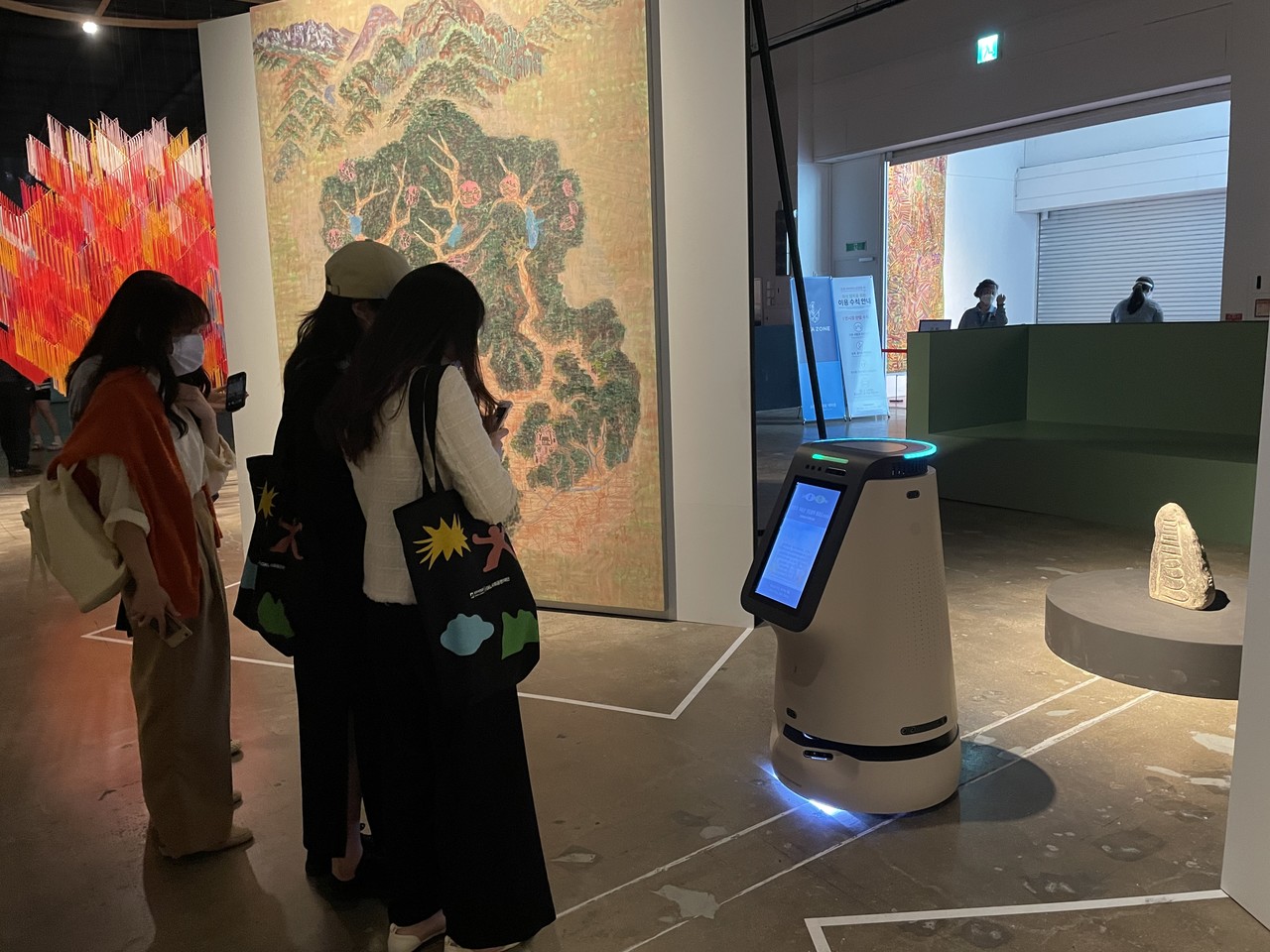 제13회 광주비엔날레가 지난 9일, 39일간의 대장정을 마무리했다. 이번 비엔날레는 AI 방역 로봇과 AI 도슨트 로봇 등이 처음으로 도입돼 시민들로부터 큰 관심을 불러모았다. 전시를 관람하는 시민들이 AI 도슨트 로봇의 안내를 받고 있는 모습. (사진=제타뱅크 제공).