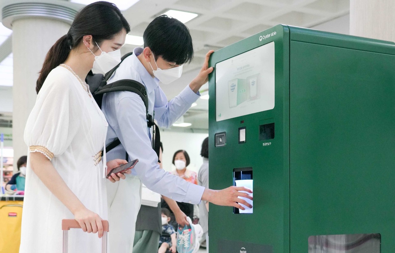 제주 관광객들이 제주국제공항 안에 설치된 무인 다회용컵 반납기를 통해 사용을 마친 컵을 반납하는 모습 (사진=
