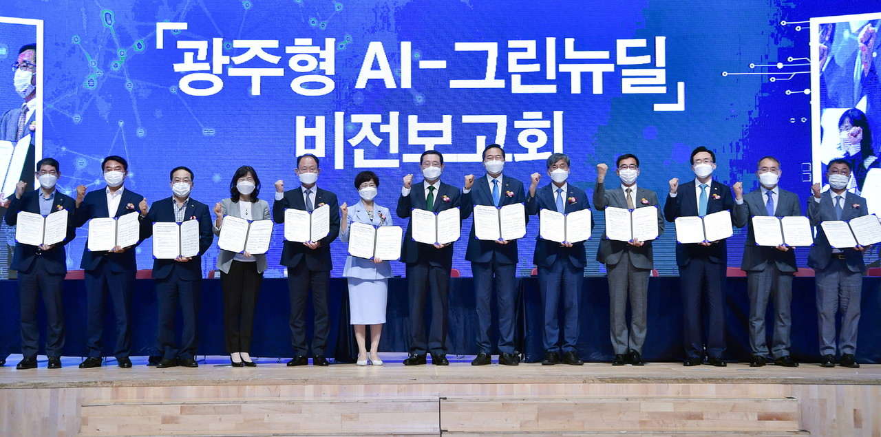 이용섭 광주광역시장이 21일 오후 서구 김대중컨벤션센터 다목적홀에서 열린 '광주형 AI-그린뉴딜' 비전 보고회에서 광주시의회, 전라남도, 한전 등 12개 기관·단체와 '광주형 AI-그린뉴딜 실현 업무협약'을 체결한 뒤 기념촬영을 하고 있다./광주광역시 제공