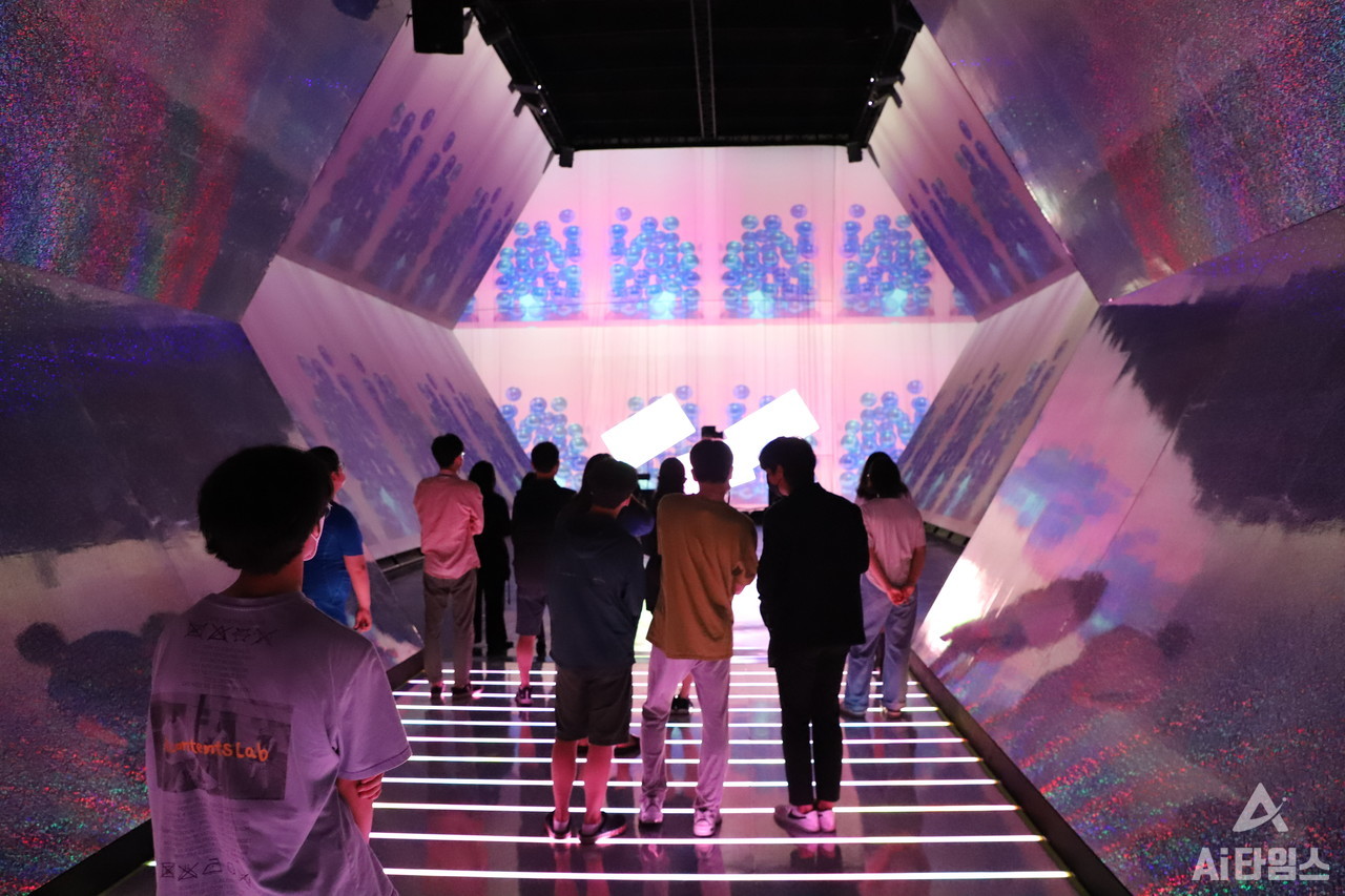 '환상극장' 전시관을 찾은 관람객들이 망원경 모양의 반사터널 안에서 작품을 감상하는 모습. (사진=구아현 기자). 