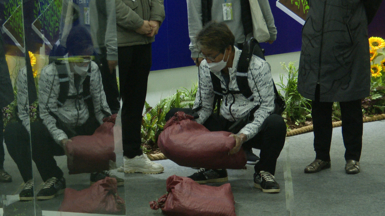 국제농업박람회 현대로템 부스에서 관람객이 웨어러블 로봇을 입고 쌀포대를 들어올리고 있다. (사진=나호정 기자).