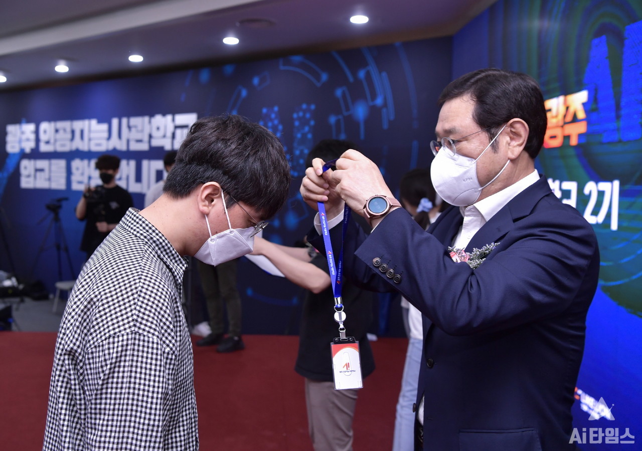 이용섭 광주광역시장이 지난 6월 15일 오후 광주과학기술진흥원에서 '인공지능사관학교 2기 교육생 입교식'에 참석해 교육생들에게 생도증을 목에 걸어주고 있다. (사진=광주광역시 제공).