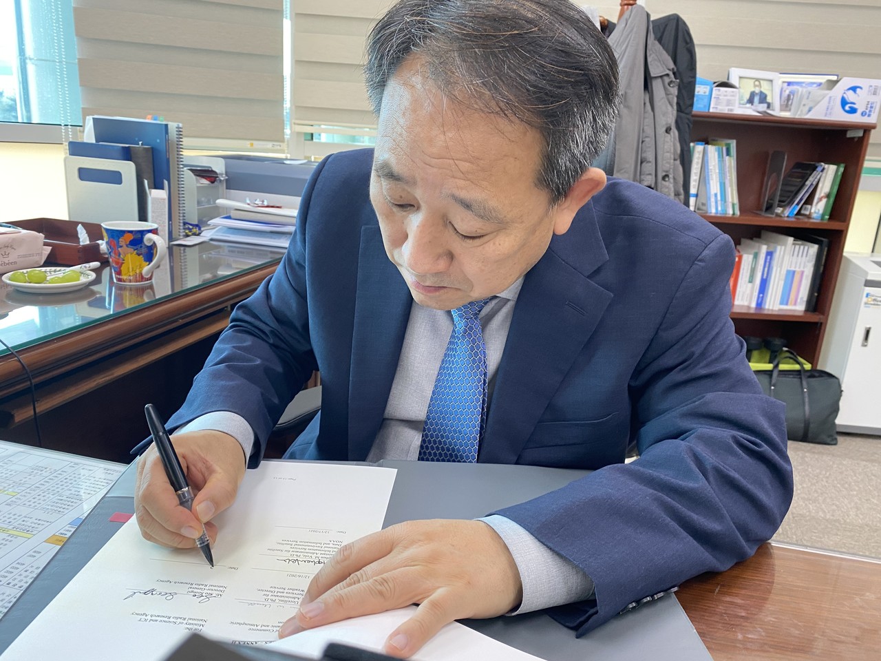 국립전파연구원 서성일 원장이 美국립해양대기청과의 우주전파 예·경보기술 협력 강화를 위한 양해각서에 서명을 하고 있다. (사진=국립전파연구원 제공).