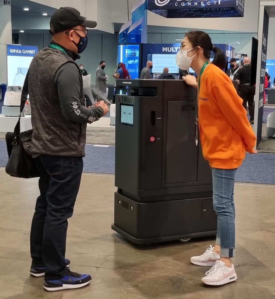 지난달 5일부터 7일(현지시간)까지 미국 라스베이거스에서 열린 CES 2022 트위니 부스에서 한 관람객이 대상추종로봇 '따르고'에 대한 설명을 듣고 있다. (사진=트위니 제공).