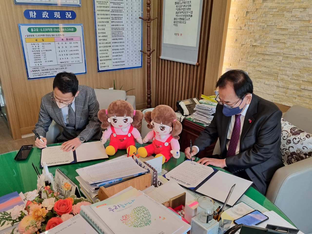 김동원 미스터마인드 대표와 김준성 영광군수가 '영광형 인공지능 스마트 돌봄체계 구축을 위한 업무협약'에 서명하고 있는 모습. (사진=미스터마인드 제공).