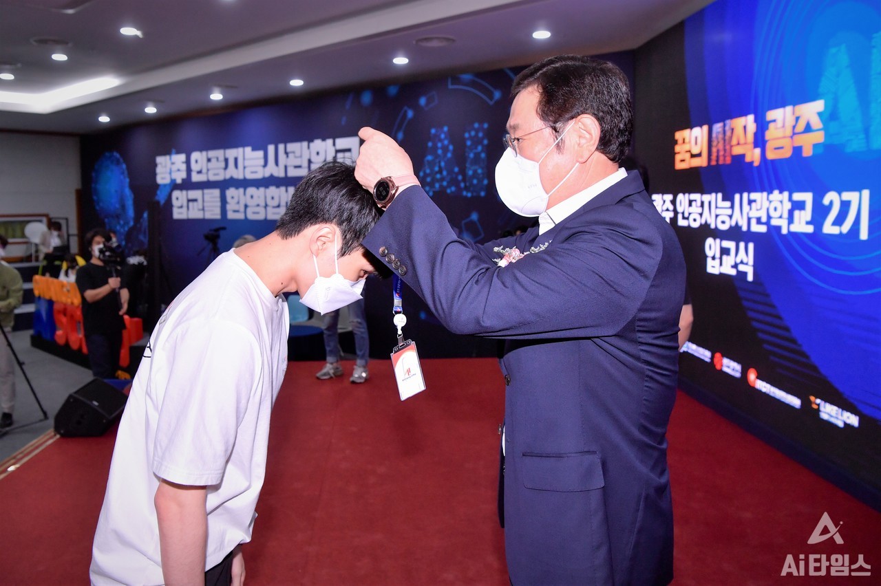 이용섭 광주광역시장이 지난해 6월 15일 오후 광주과학기술진흥원에서 '인공지능사관학교 2기 교육생 입교식'에 참석해 교육생들에게 생도증을 목에 걸어주고 있다. (사진=광주광역시 제공).