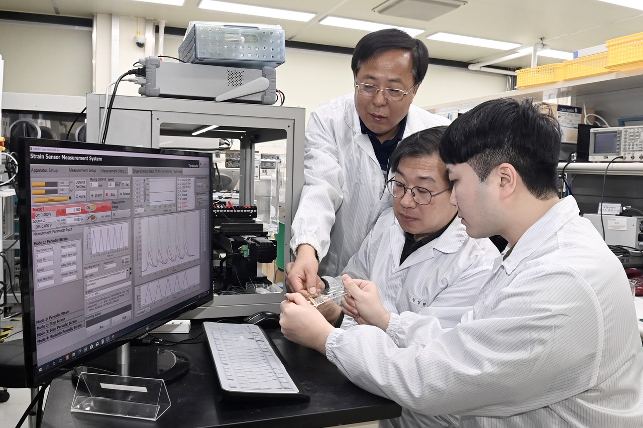 ETRI 연구진이 스트레인 센서의 신축량과 변형방향을 측정하고 있다. (tkwls=ㄸㅆ꺄)