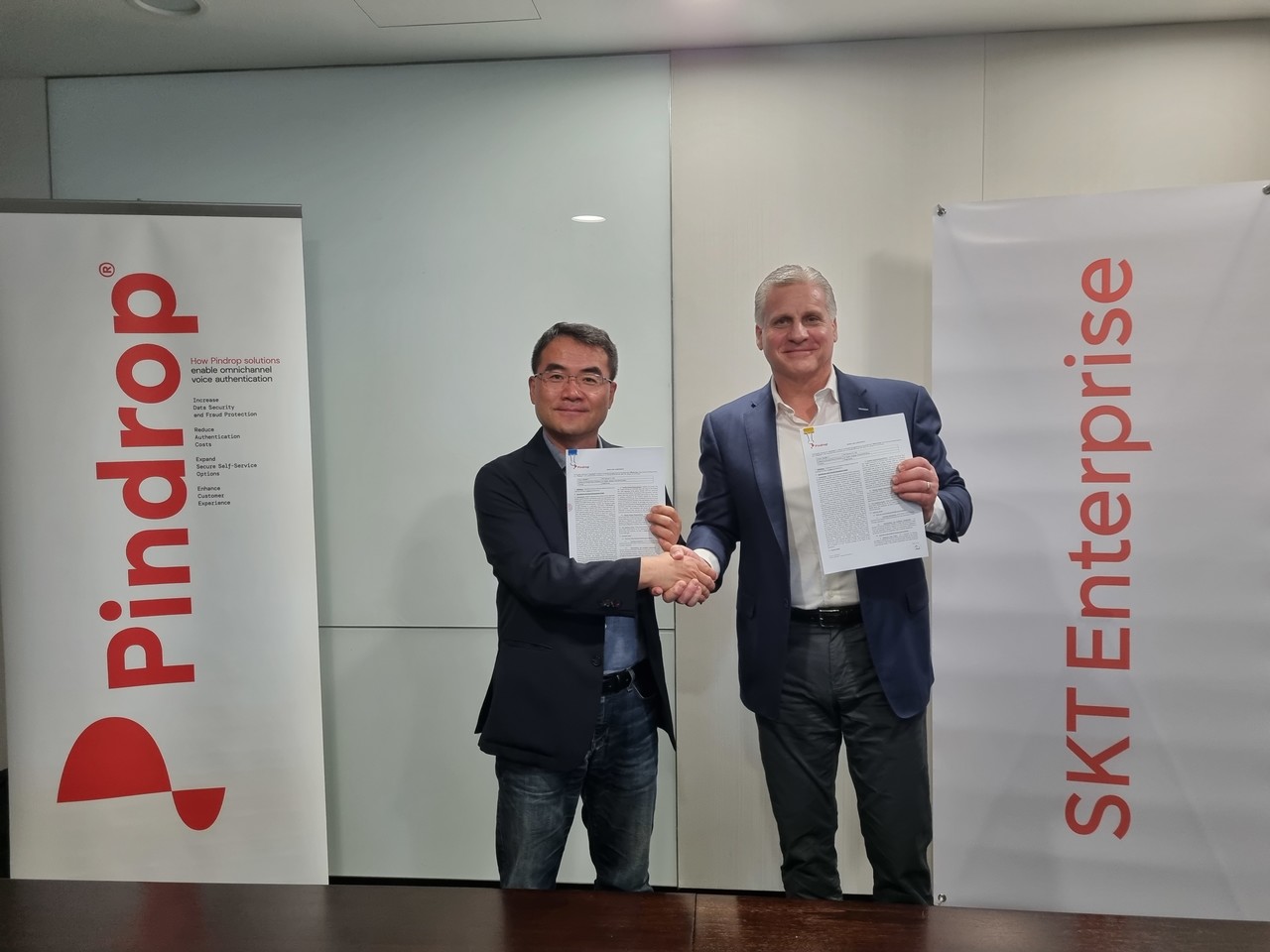 SKT가 음성기술 선도기업 핀드롭(Pindrop)과 함께 음성인증AI 상품을 출시했다. 이규식 SKT 엔터프라이즈  AI사업담당과 마이클 휴즈 핀드롭 부사장이 음성인증 AI 서비스 공동사업을 위한 협약에 서명한 후 악수를 나누고 있다.