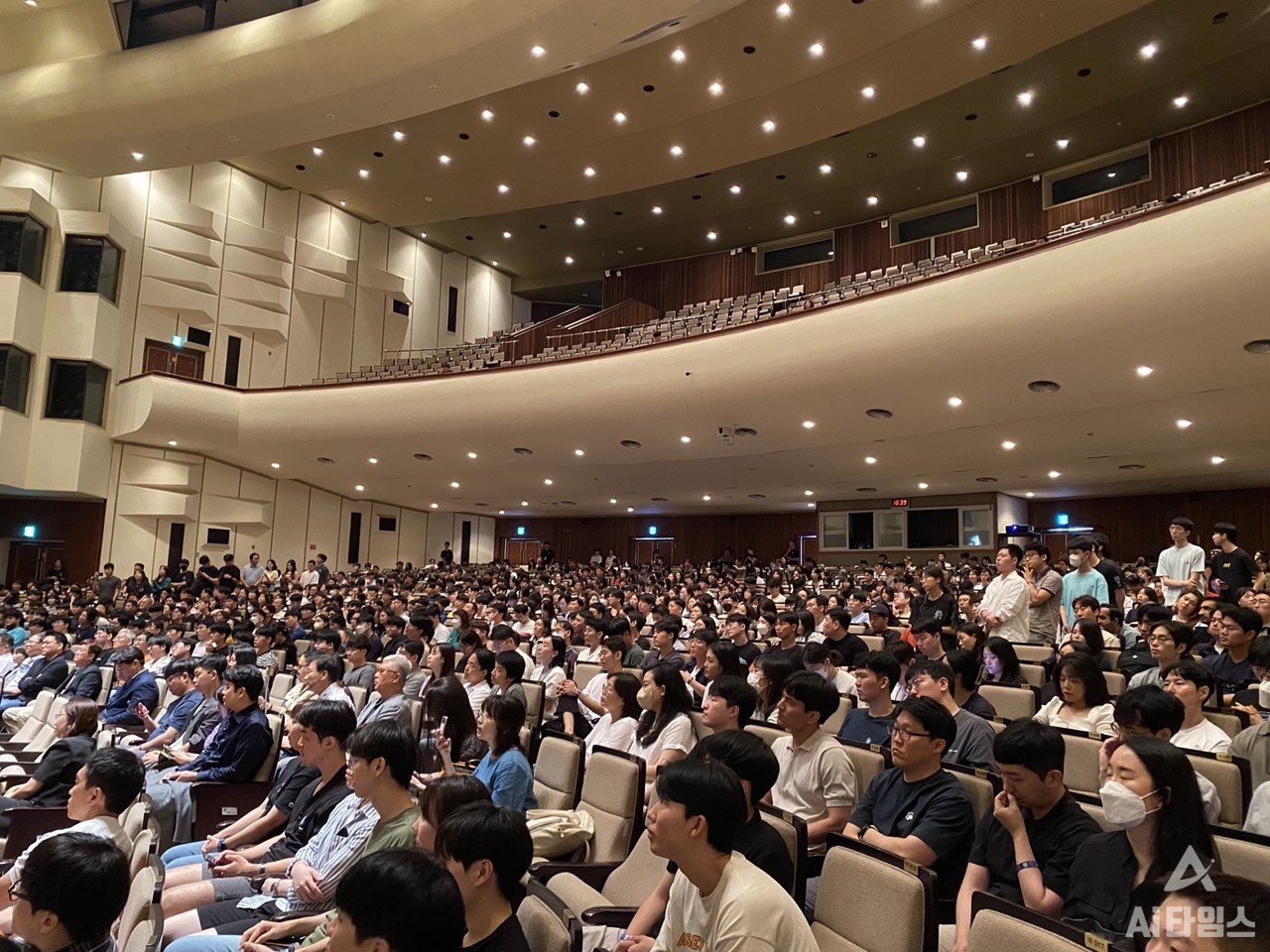 The audience gathered to participate in the question-and-answer session.  You can also see people lined up on both sides to participate in the question and answer session. 