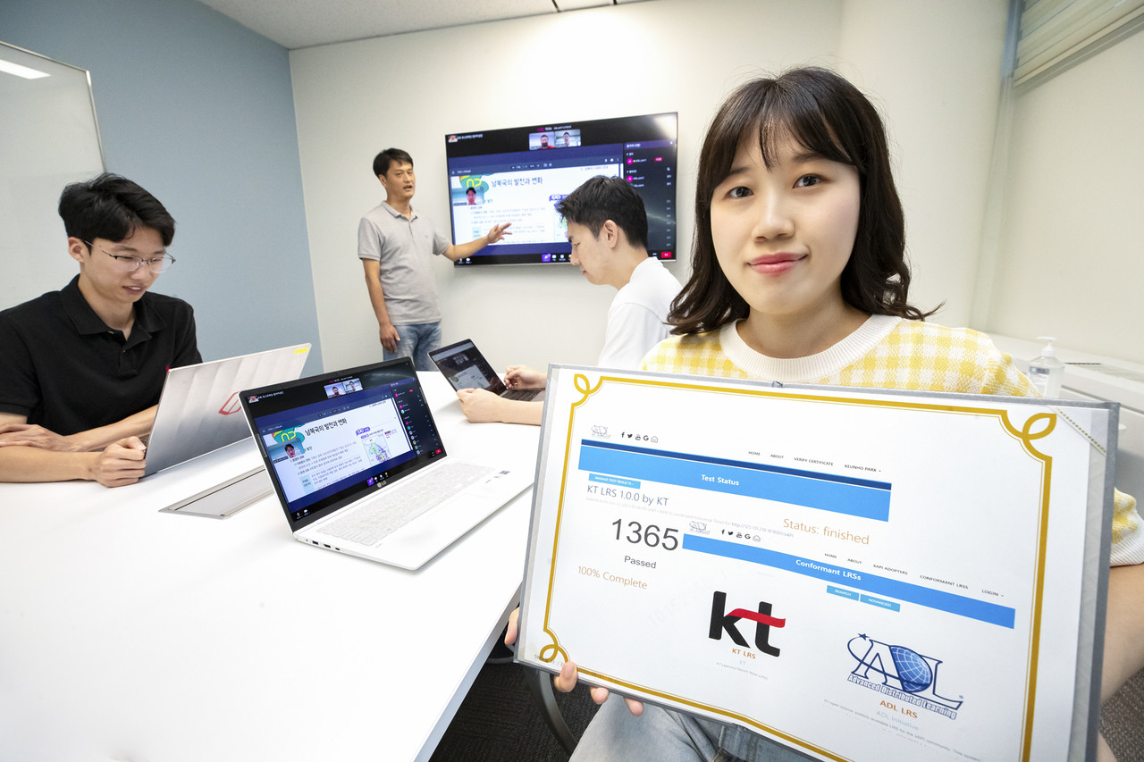  KT 융합기술원 연구원이 KT 학습분석솔루션의 ADL 글로벌 표준 인증서를 들어 보이고 있다. (사진=KT) 