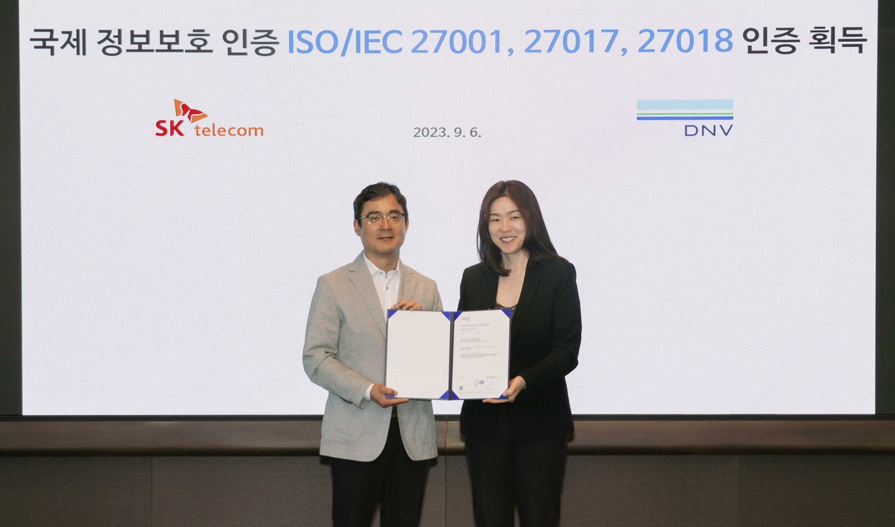 손영규 SKT 정보보호담당(왼쪽)과 이소영 디엔브이 비즈니스 어슈어런스 코리아 대표가 인증서를 들고 포즈를 취하고 있다. (사진=SKT) 