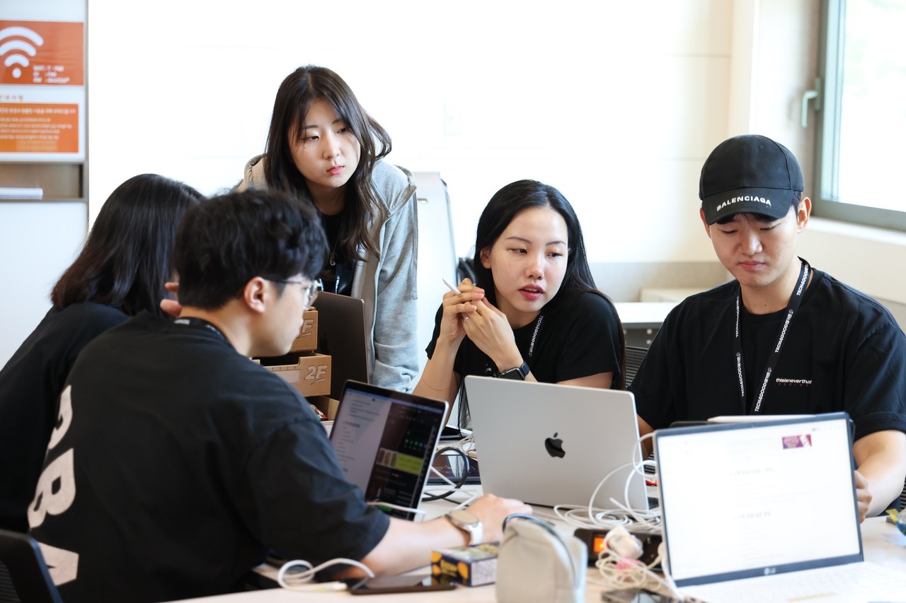 해커톤 현장에서 대학생들이 멘토와 함께 아이디어 회의를 하고 있다. (사진=SKT)