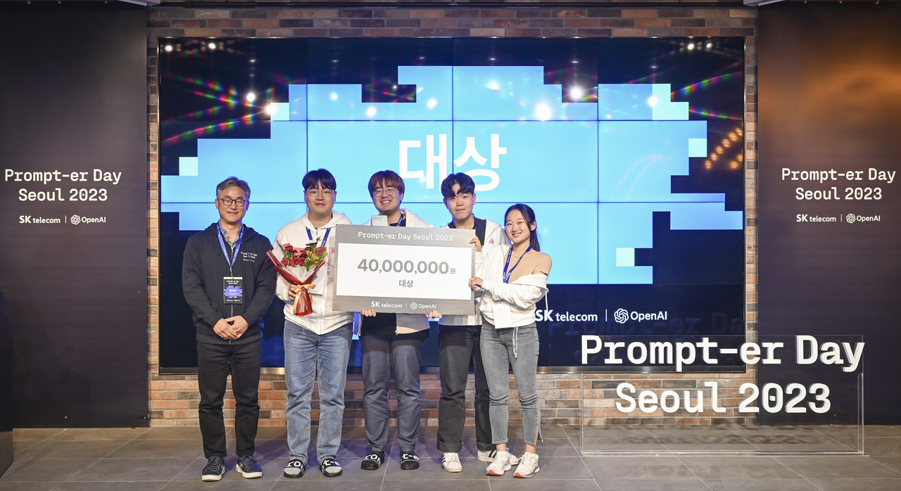 정석근 SKT 글로벌/AITech 사업부장(왼쪽)과 대상 수상팀 ‘선천적프롬프터들’(오른쪽)이 기념촬영을 하고 있다. (사진=SKT)