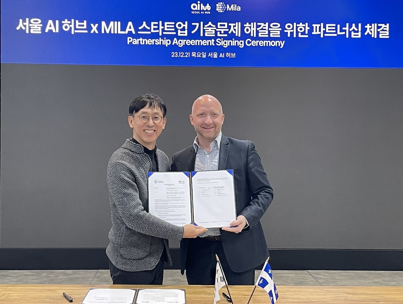 함종민 서울 AI 허브 센터장(왼쪽)과 프레드릭 로랑 밀라 AI 연구소 파트너십 시니어 디렉터가 파트너십 체결 기념 사진 촬영을 하고 있다. (사진=서울AI허브)