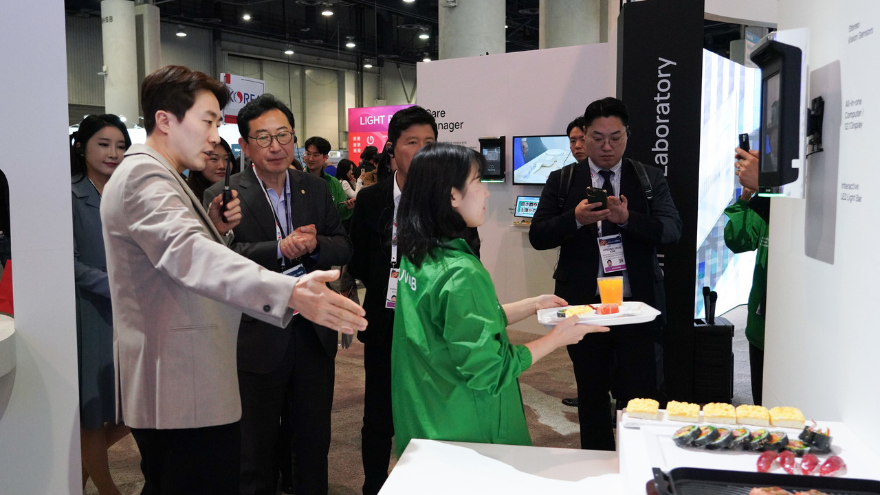 누비랩 직원이 CES 2024 부스를 방문한 산중위에 신규 AI 푸드 스캐너를 시연하고 있다. (사진=누비랩)