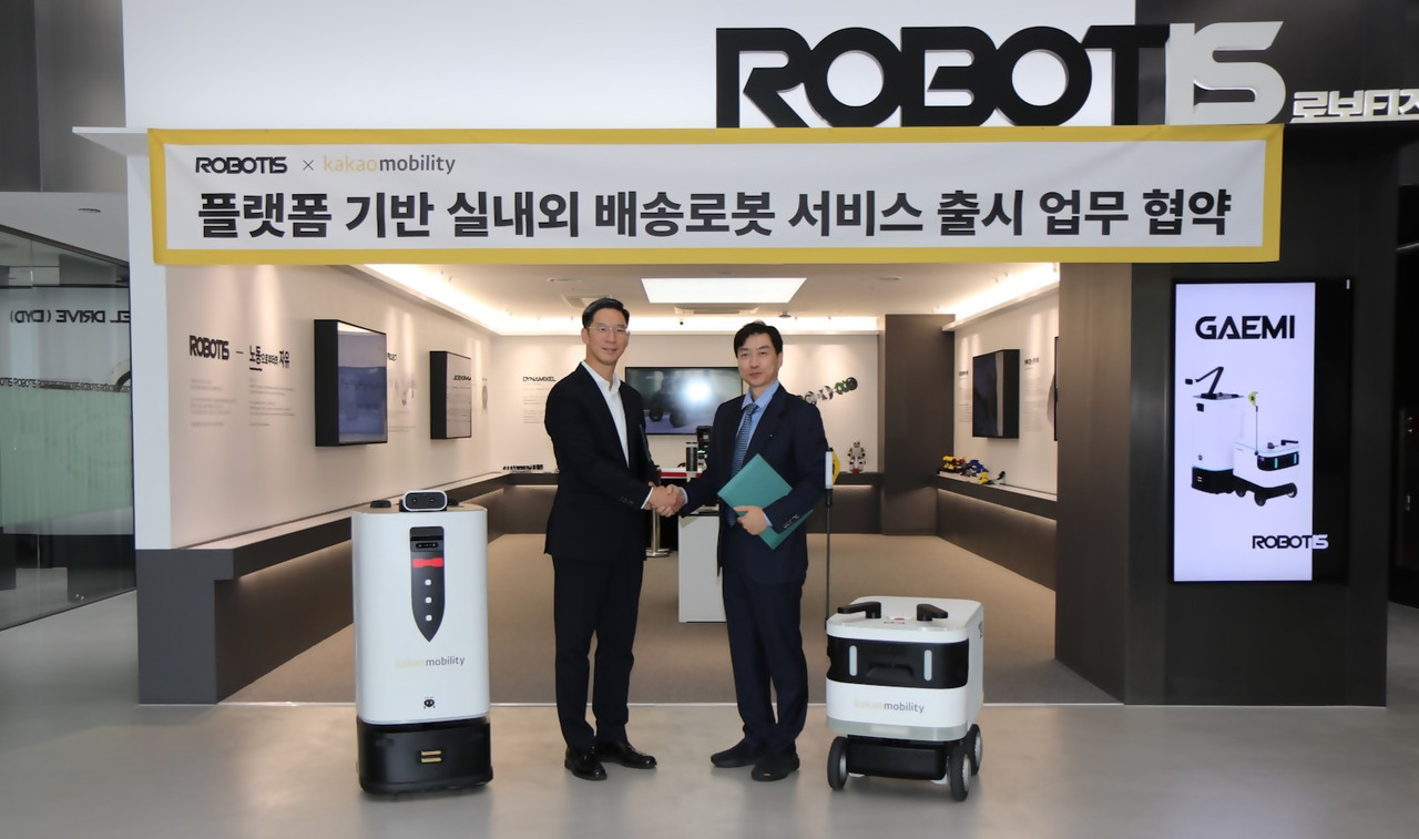 장성욱 카카오모빌리티 미래이동연구소장(왼쪽)과 김병수 로보티즈 대표(오른쪽)가 서울 강서구의 로보티즈 본사에서 협약식을 마친 뒤 기념사진을 촬영하고 있다. (사진=카카오모빌리티)