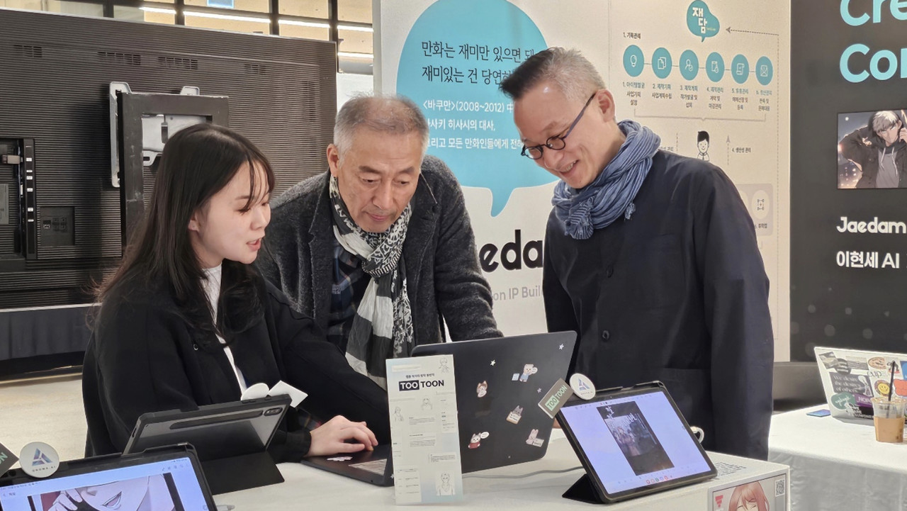 이현세 작가(가운데)가 'AI 콘텐츠 페스티벌'에서 오노마AI의 투툰 서비스를 시연하고 있다. (사진=오노마AI)