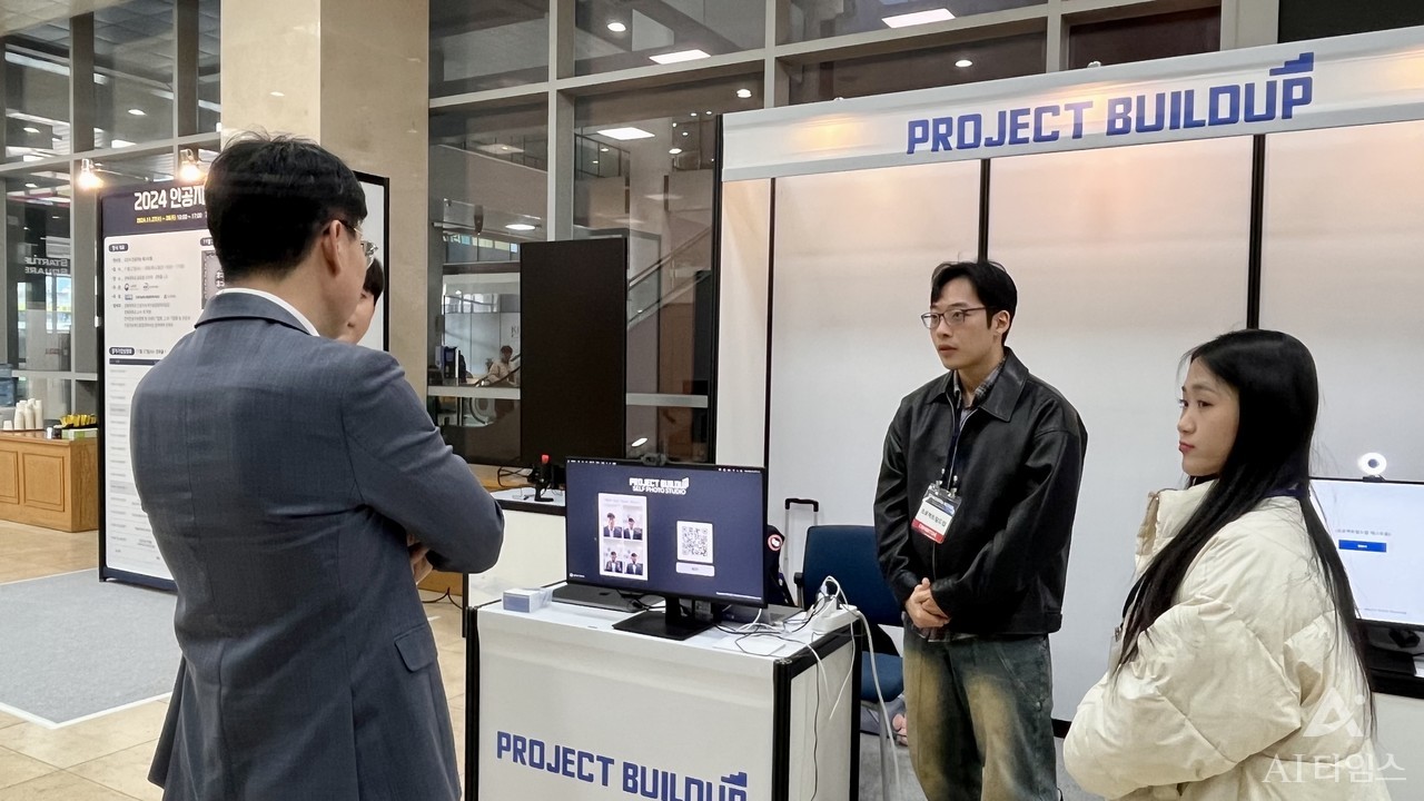 Project build-up booth set up at Kyungpook National University Global Plaza Gyeongha Hall. Hwalmin Lee, a student in the Department of Electronic Engineering at Kyungpook National University, is explaining to visitors.