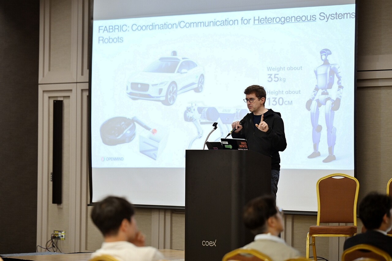 얀 리프하르트 오픈마인드 설립자 겸 CEO가 26일 서울 코엑스에서 열린 '오픈 로보틱스 AI 포럼 코리아'에서 '분산형 AI 시대, 기계 자율성의 점화, 생각하고 학습, 협력하는 머신'을 주제로 기조연설을 하고 있다. (사진=오픈마인드)