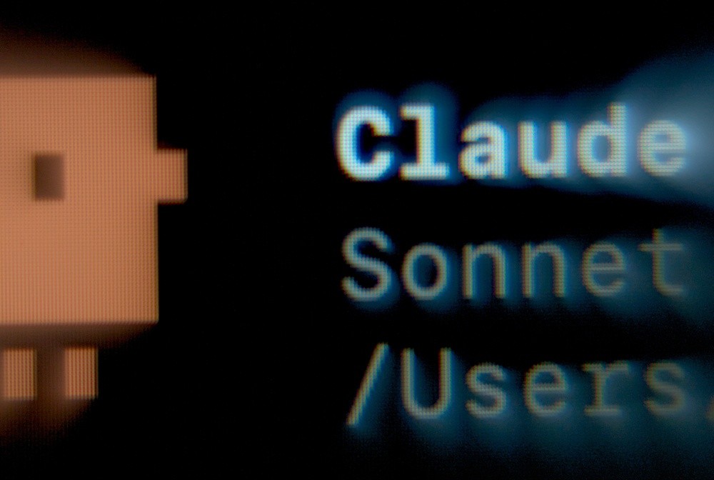 Görsel, koyu bir arka plan üzerinde pikselli bir blok karakteri ve “Claude Sonnet /Users” metnini göstermektedir.